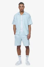 baby blue structured knit shirt oversized fit dropped shoulders white logo stich to the front reverse collar and button placket